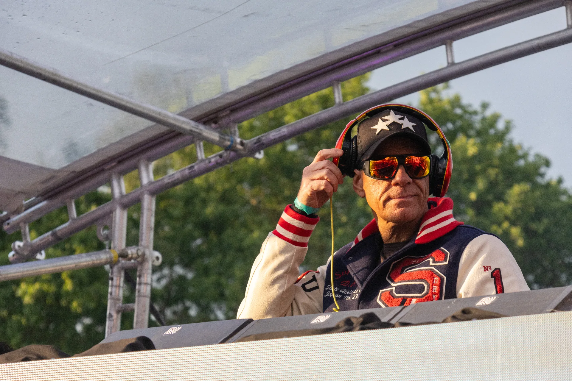DJ met koptelefoon achter Pioneer draaitafels in het gouden uur