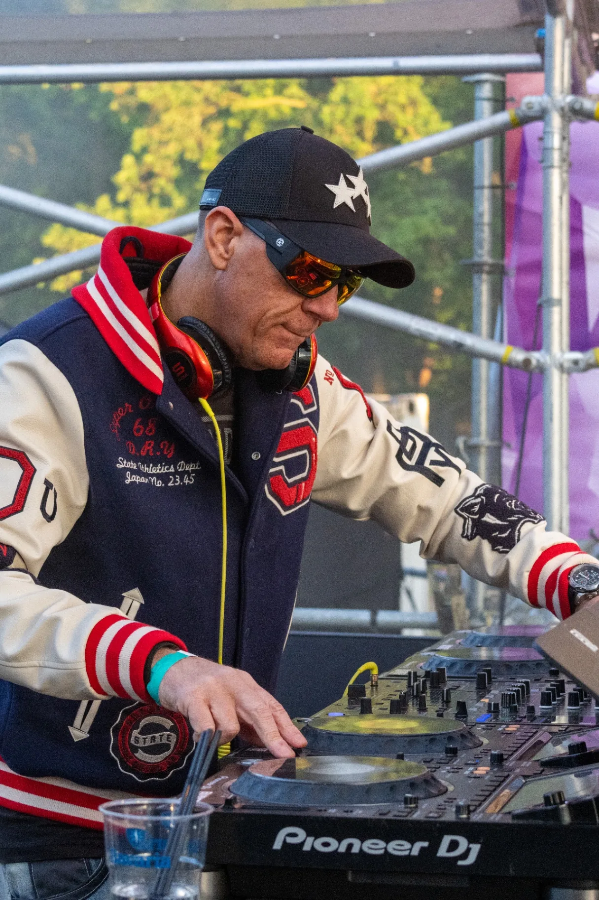 DJ van achteren achter draaitafels met juichend publiek