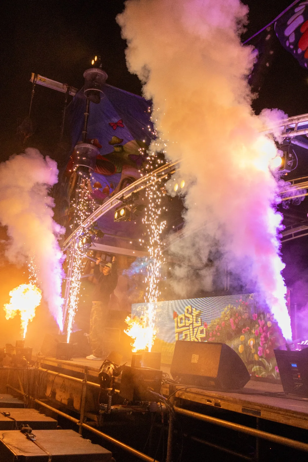 Vuurwerk fonteinen en vuurkanonnen op podium met paarse rook
