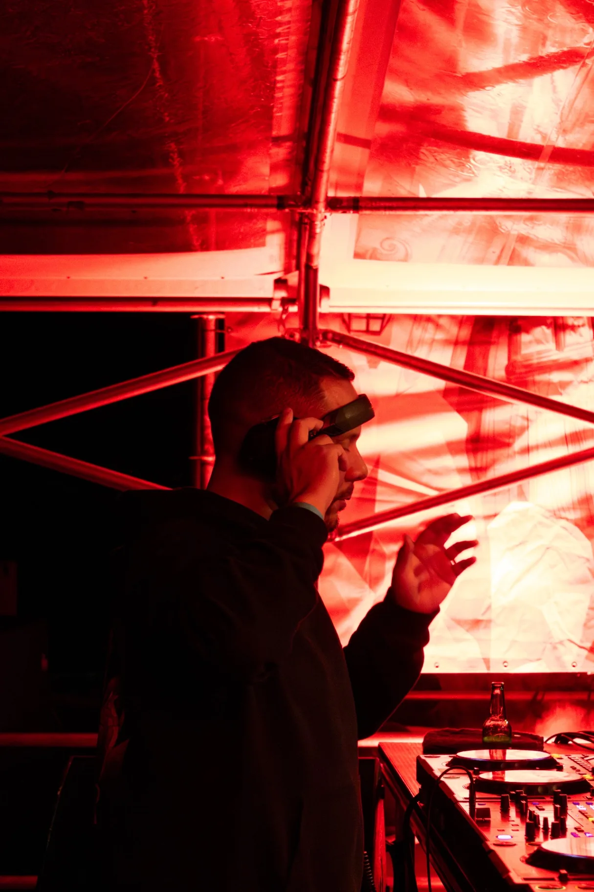 DJ portret onder rood tentlicht met sigaar backstage